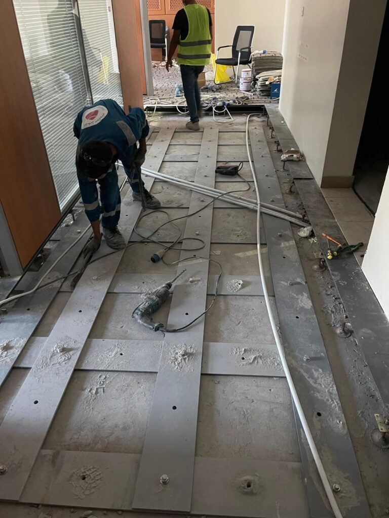 Steel straps anchored to the concrete slab to prevent further deflection.